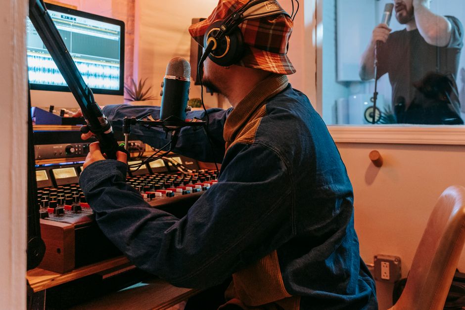 Music producer and vocalist collaborating in a professional studio environment.